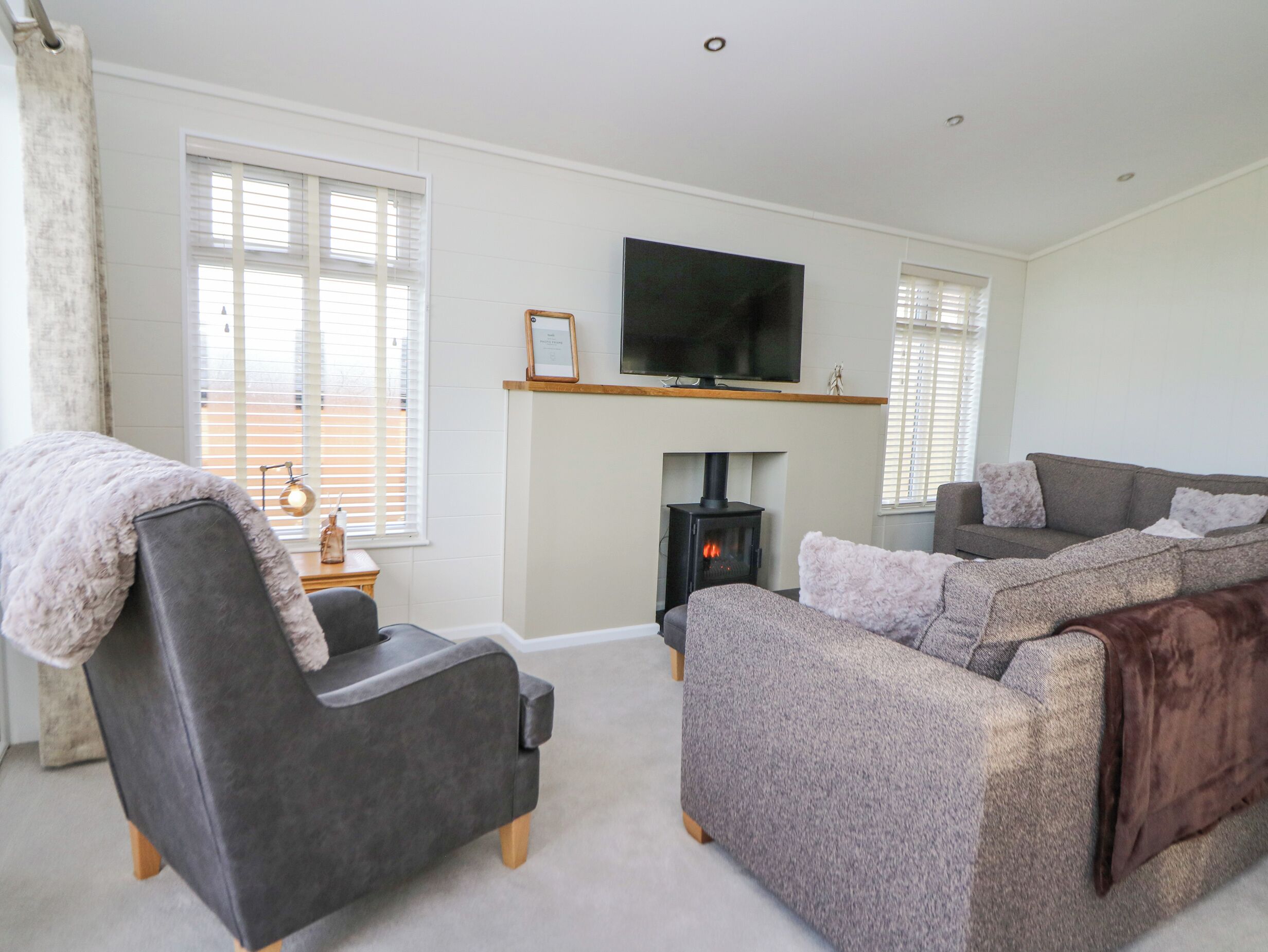 A living room with a sofa, armchair, and a fireplace.