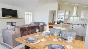 Un espacio habitable moderno con comedor, sofá y cocina.