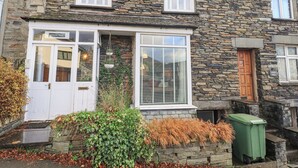 A stone building with a white door, a window with shutters, and a sign that reads "Silver How". - Silverhow Cottage (Ambleside)