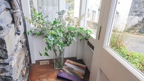 A corner of a room with a wooden shelf, a vase with green foliage, and a book titled "Lake Lure & District". - Silverhow Cottage (Ambleside)