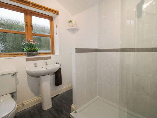 A bathroom with a toilet, sink, and shower. - Clandyke Cottage (Ludlow)