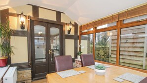 A dining area with a wooden table, chairs, and a potted plant. - Clandyke Cottage (Ludlow)