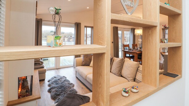 Un salon moderne avec un plancher en bois, un canapé, une table basse et une cheminée.
