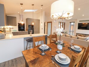 A modern kitchen with grey cabinets, a central island, and pendant lighting. - 12A Lake Escape (Carnforth)