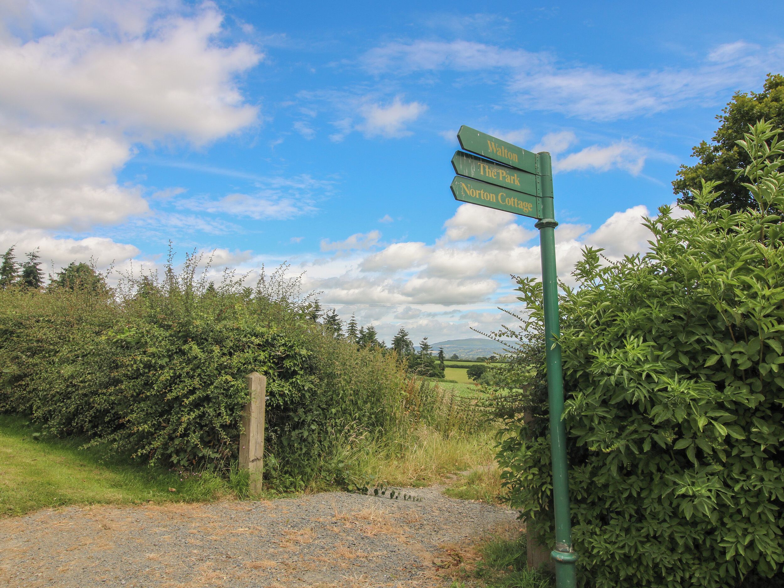 Un panneau indicateur avec trois flèches pointant vers Walton, The Park et Norton Cottage.