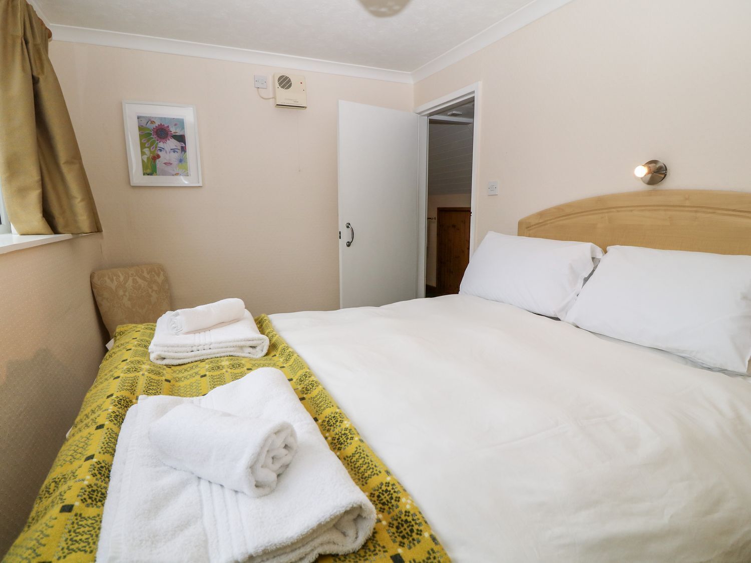 Ein Hotelzimmer mit einem Bett, einem Sessel, einem Gemälde und einer Tür.