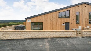 A modern building with a wooden facade, a glass entrance, and a sign indicating it is a court. - Bears Court Barn 1 (Cheltenham)