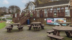 A restaurant with outdoor seating and a sign advertising a £5 off offer on any grill dish. - 6 Manor Park (Bideford)