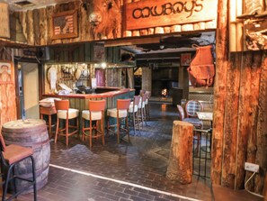A rustic bar area with wooden furniture and a sign reading "Cowboys". - Bear Claw Lodge (Limavady)