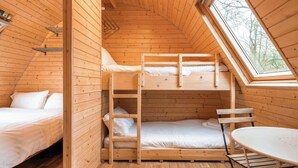 A cozy cabin with a loft bed, a lower bunk, and a small table. - Lakeside Pods - Pets Welcome (Oldham)
