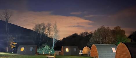 A row of modern, dome-shaped cabins with a stone pathway leading through the center.
