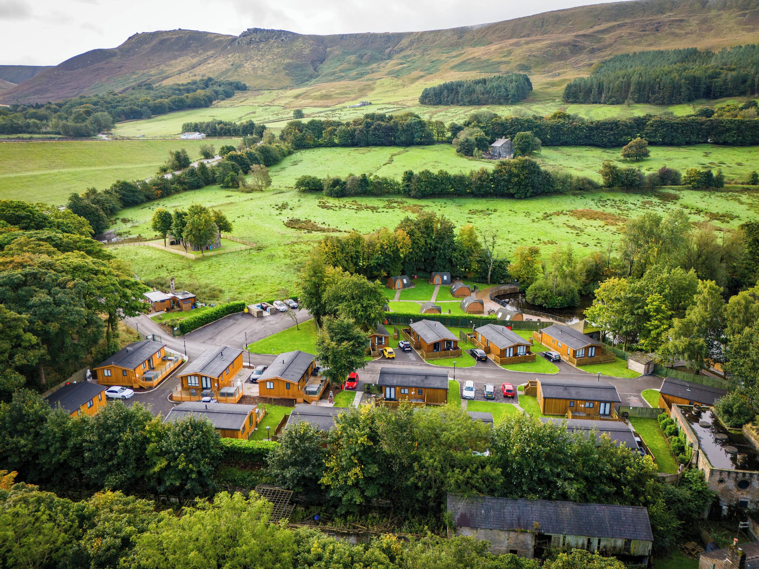 A rural village with traditional cottages, a central square, and surrounding green fields.