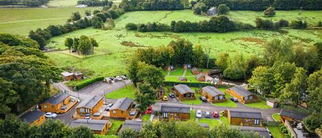 A rural village with traditional cottages, a central square, and surrounding green fields.