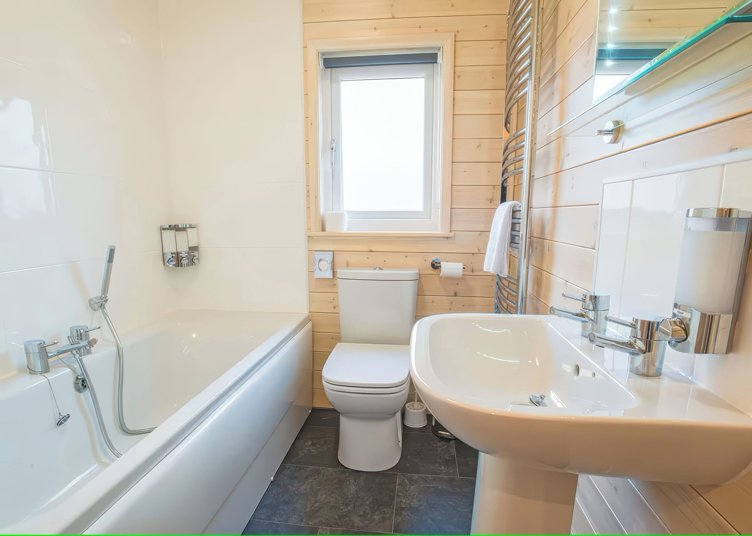A modern bathroom with a bathtub, toilet, and sink.