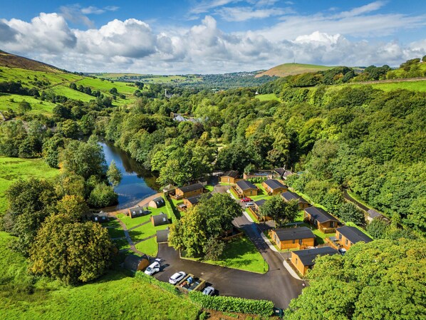A rural village with traditional cottages, a river, and a small church. - Dovestone Luxury Lodges - Pets Welcome (Oldham)