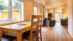 Un intérieur en bois comprenant une table à manger, des chaises, des canapés et un téléviseur.