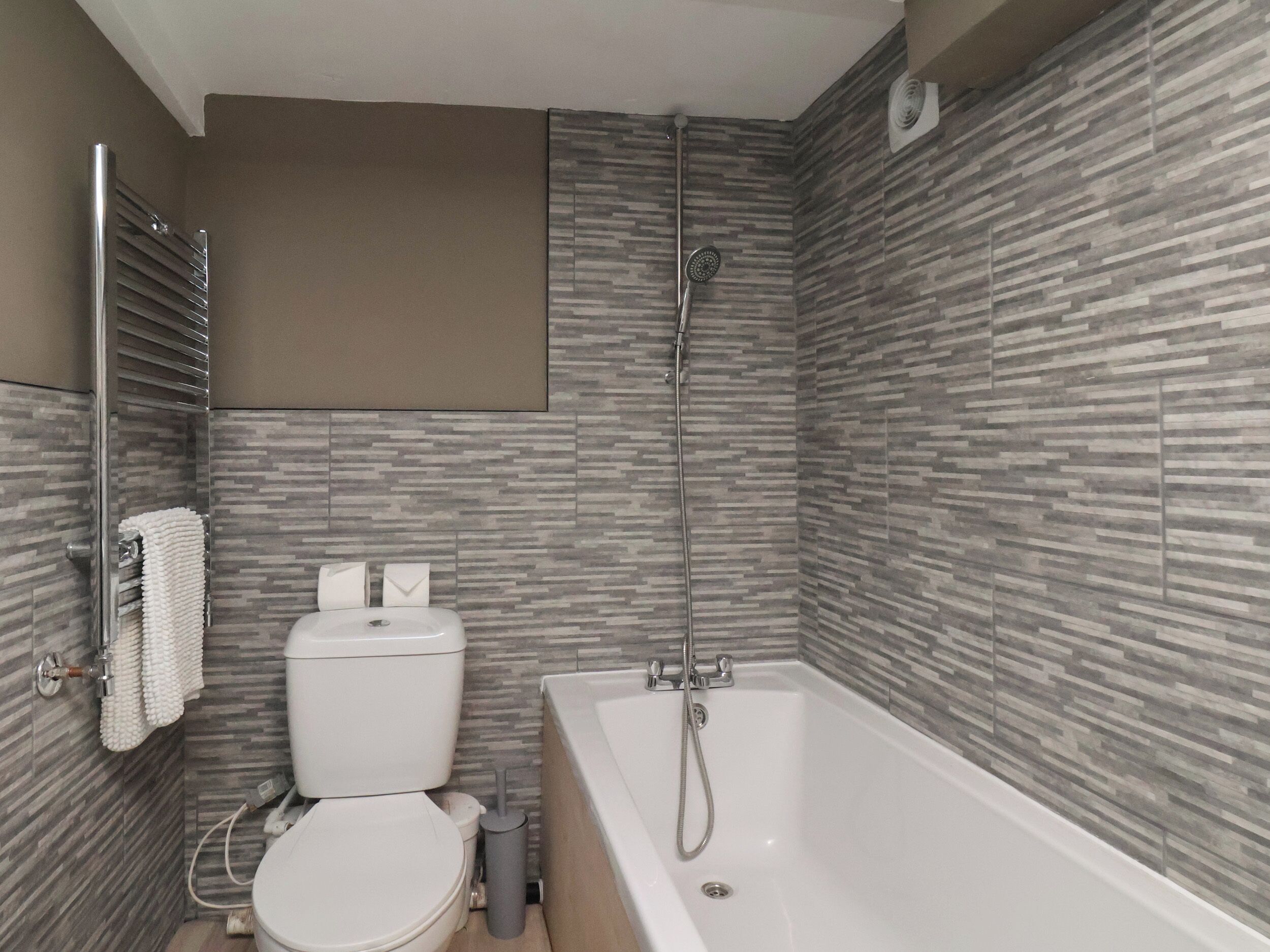 Un baño moderno con inodoro, bañera y ducha.