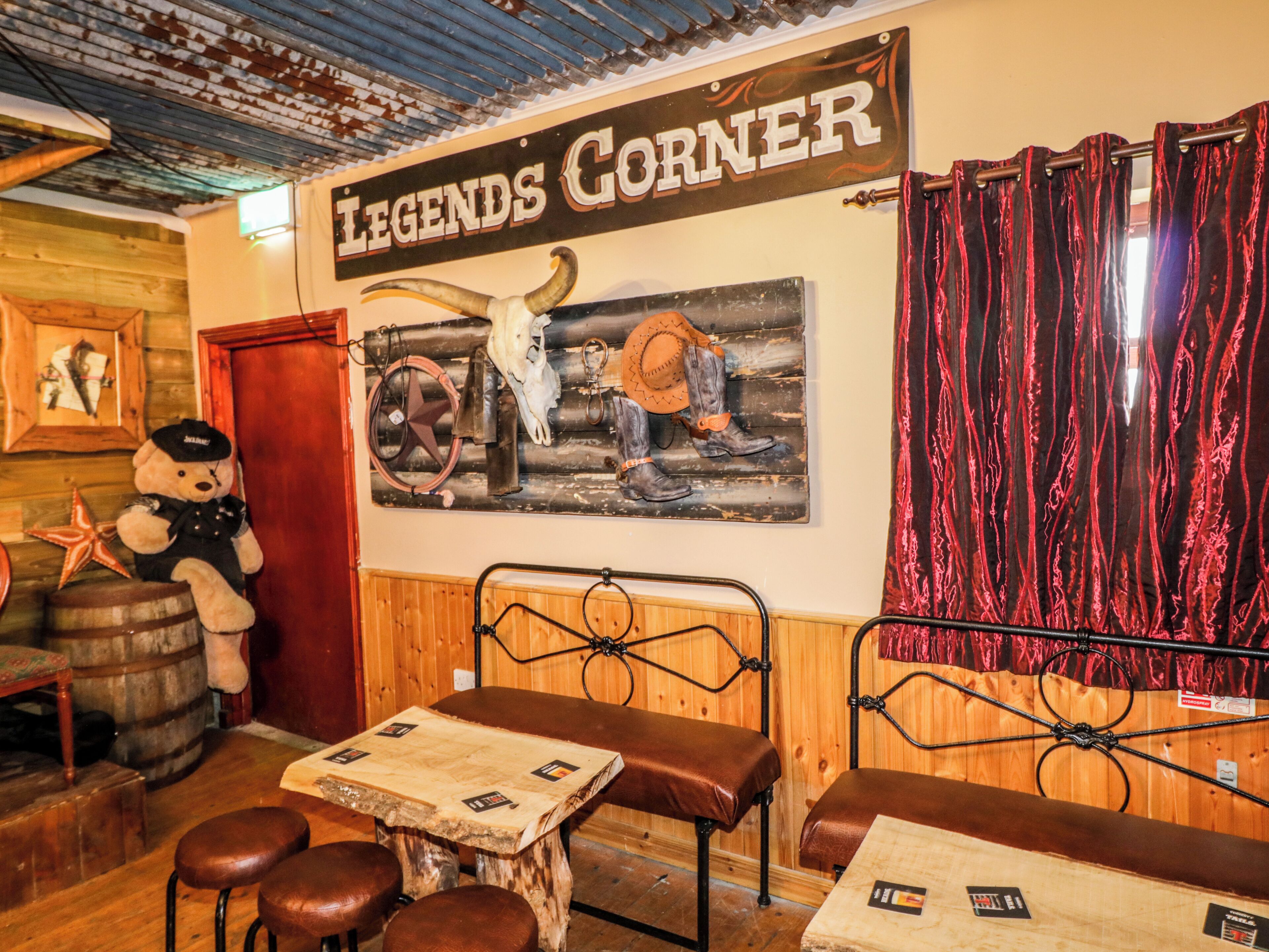 Un bar de estilo rústico con paredes y techo de madera, y un letrero que dice 