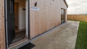 Un bâtiment en bois avec une enseigne indiquant « BEARS COURT 4 » et un patio en béton avec une zone herbeuse.