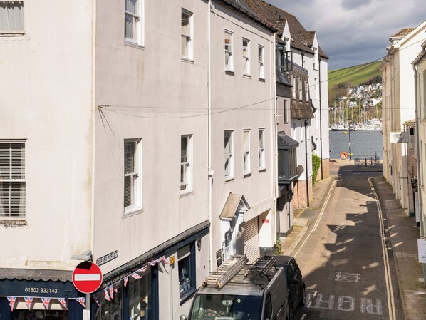 A narrow street with buildings on both sides, a no entry sign, and a view of the sea with boats. - Sunnyhaven (Dartmouth)