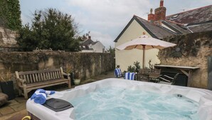 Ein Whirlpool im Hinterhof mit einer Bank, einem Tisch und einem Stuhl.