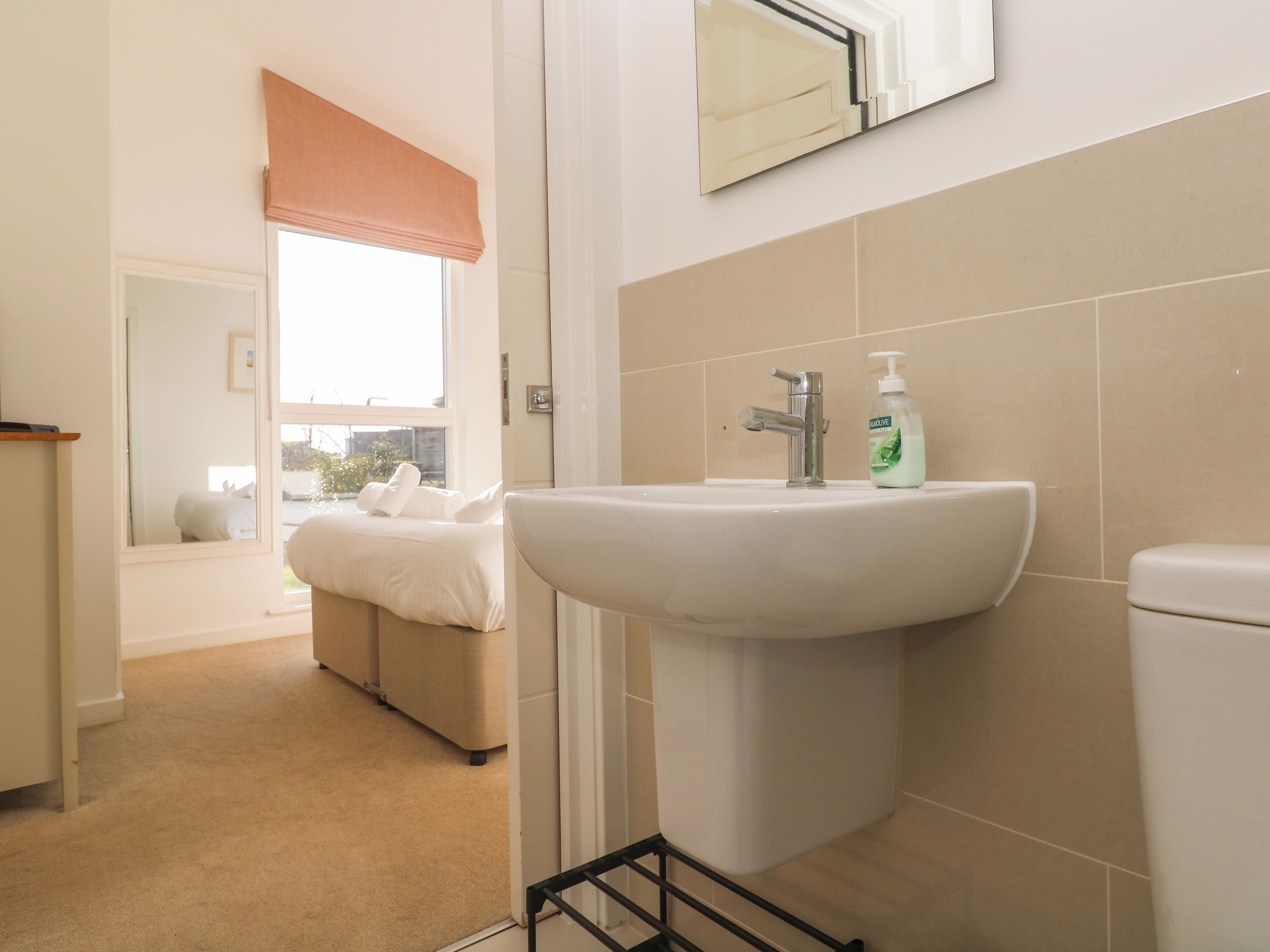 A bathroom with a sink, toilet, and a window with a view.