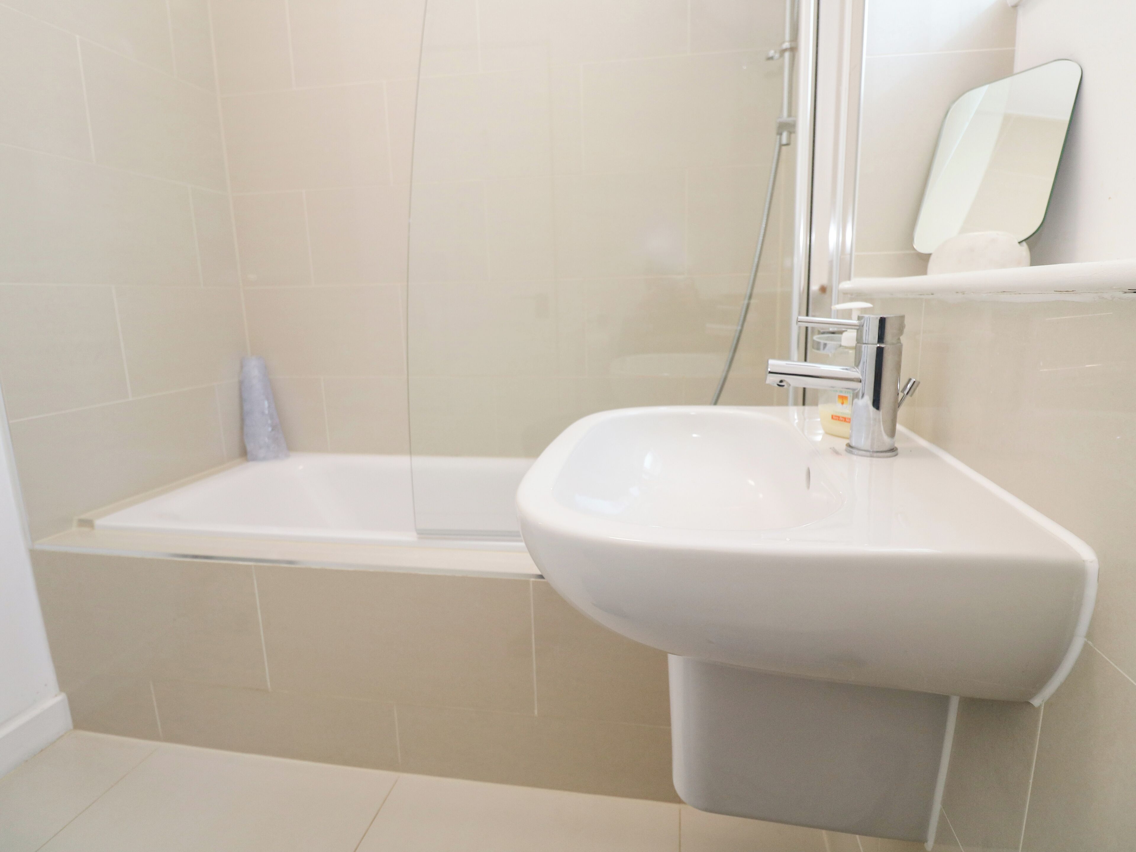 Un baño con una bañera, un lavabo y un espejo.