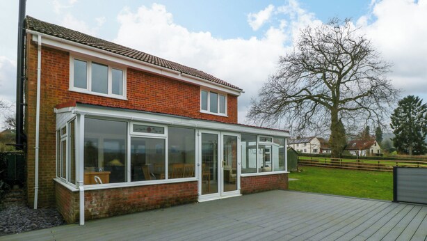 A two-story house with a patio and a conservatory. - 14 Birchwood Road (Lydney)