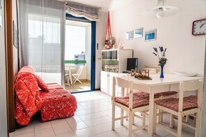 Relax in this open-plan living and dining area, featuring a sofa, dining table, and cabinet.