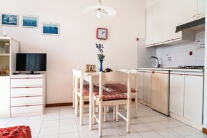 Enjoy meals and entertainment in this well-equipped kitchen with a dining table for four, TV, and modern appliances.