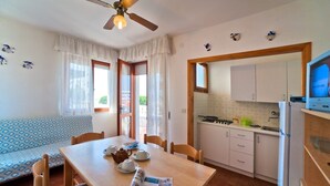 Eine gemütliche Küche mit Essbereich, Holzschränken und Deckenventilator.