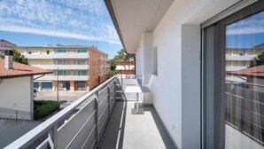 A balcony with a view of neighboring buildings and a clear sky. - Newly renovated modern two room apartment (Bibione)