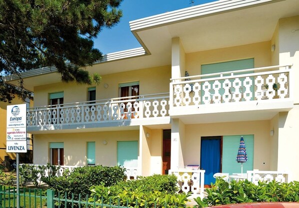 A two-story hotel with balconies, a sign indicating it is part of the Europa group, and a blue door.