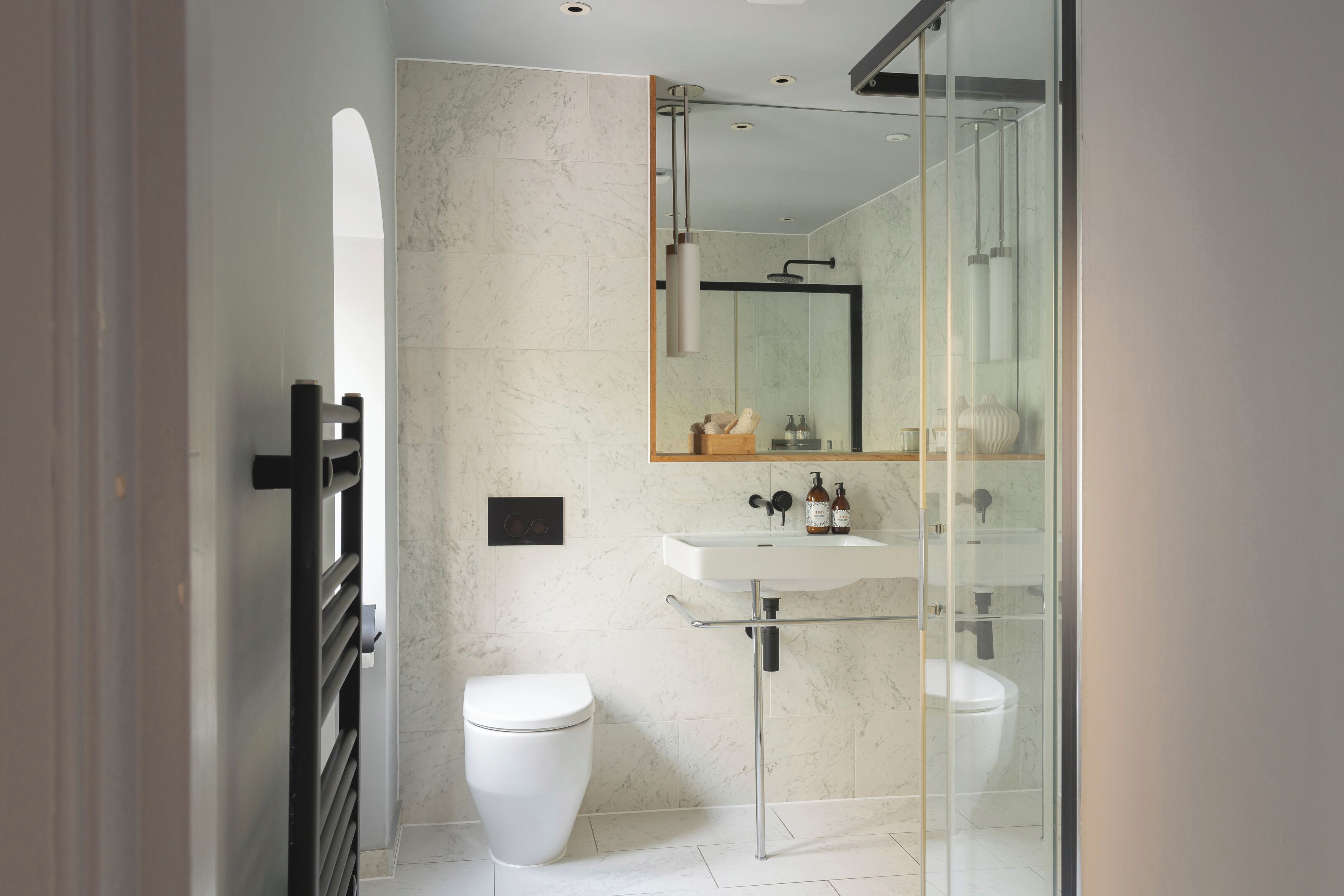 Une salle de bain moderne avec une douche à parois de verre, un lavabo blanc et des toilettes.