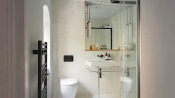 Une salle de bain moderne avec une douche à parois de verre, un lavabo blanc et des toilettes.