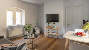Una sala de estar moderna con un sofá, una mesa de centro y un comedor con una mesa y sillas.