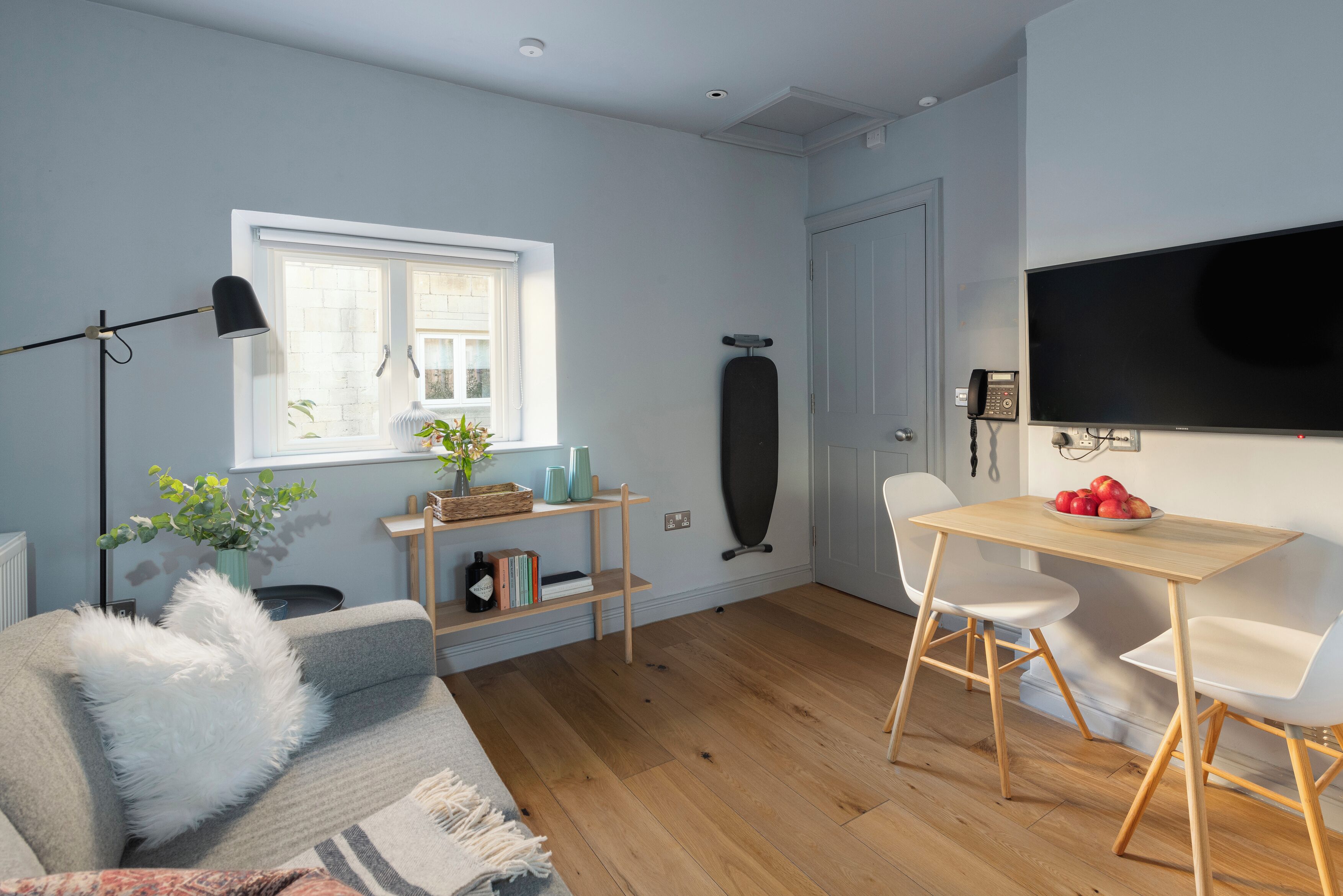 Ein modernes Wohnzimmer mit einer Couch, einem Couchtisch, einem Fernseher und einem Essbereich mit Stühlen.