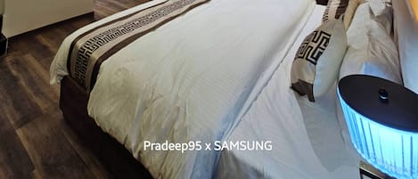 A hotel room with three beds, a ceiling fan, an air conditioning unit, and a small window.