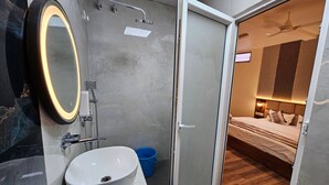 Une salle de bain moderne avec un grand miroir, un lavabo et une douche.