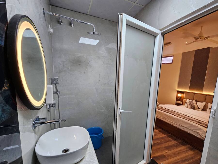 Un baño moderno con un espejo grande, un lavamanos y una ducha.