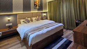 Une chambre d’hôtel moderne dotée d’un grand lit, d’un ventilateur de plafond, d’un système de climatisation et offrant une vue sur la ville par la fenêtre.