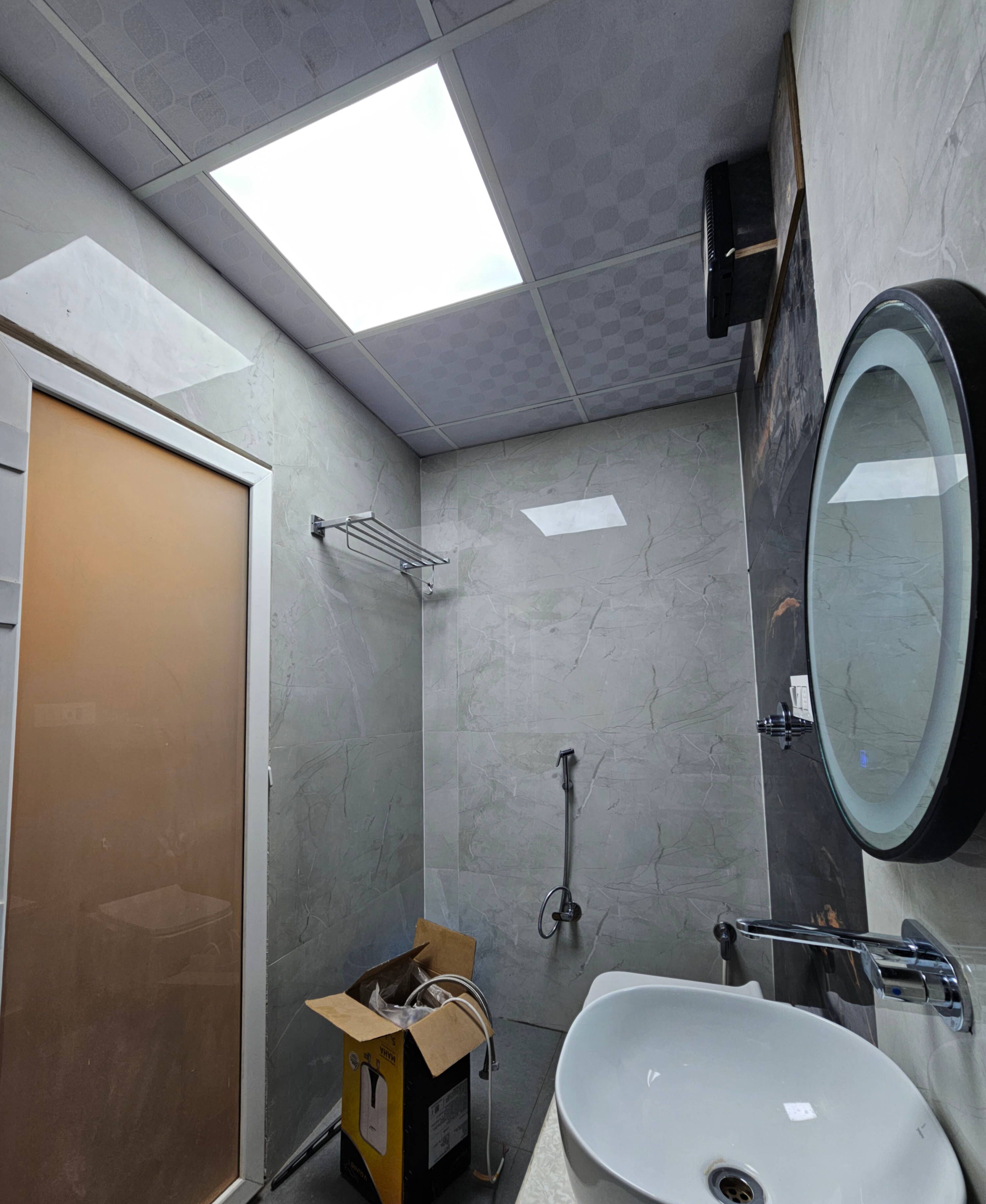 A bathroom with a shower, a sink, a mirror, and a toilet.