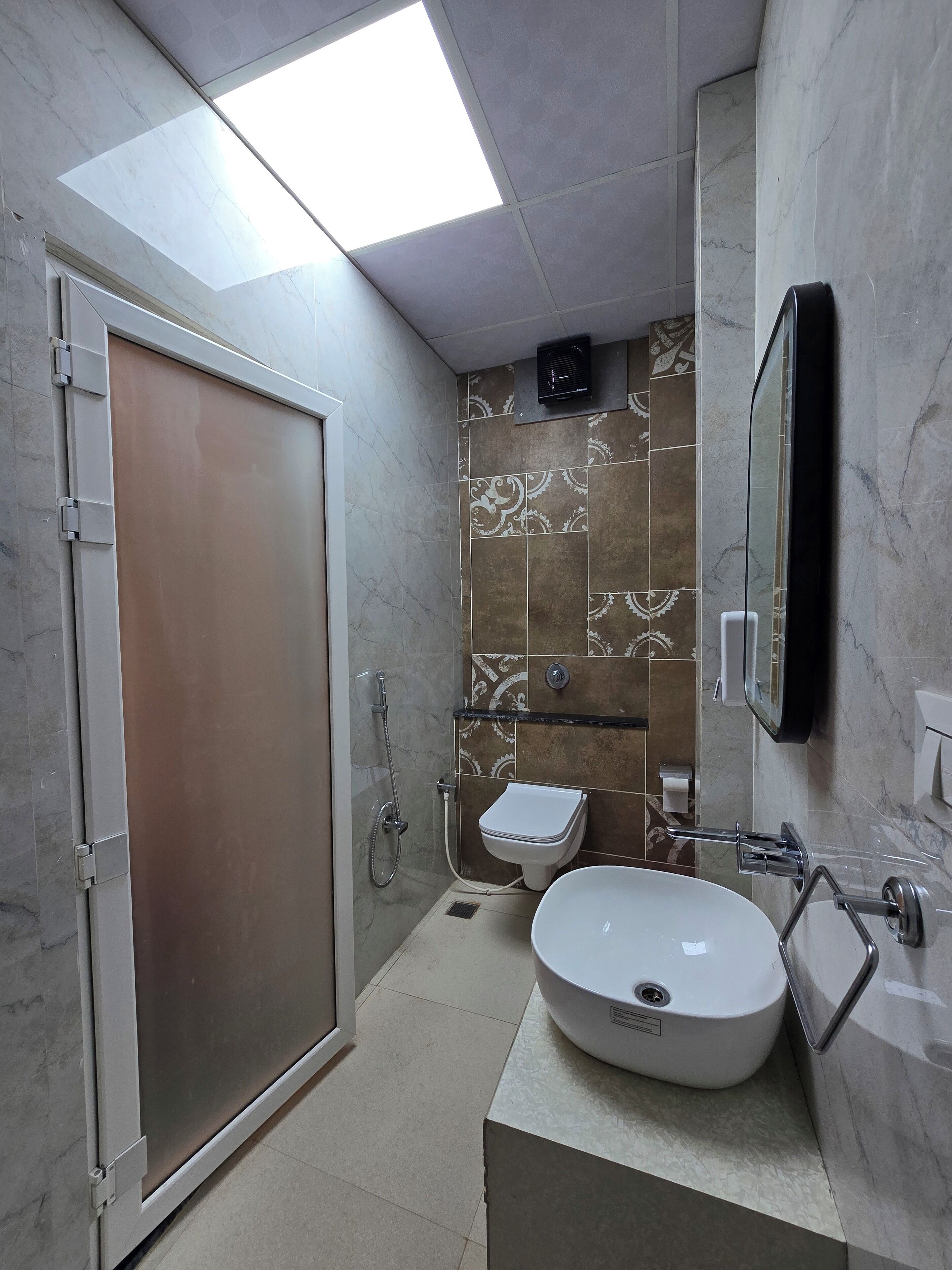 A modern bathroom with a walk-in shower, a toilet, and a sink.