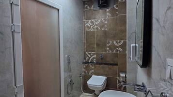 A modern bathroom with a walk-in shower, a toilet, and a sink.