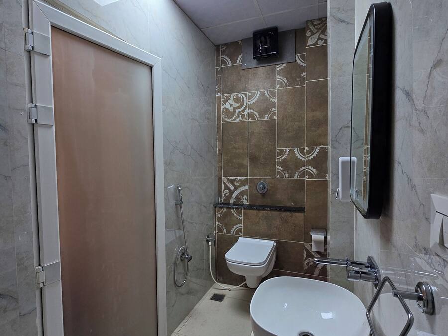 A modern bathroom with a walk-in shower, a toilet, and a sink.
