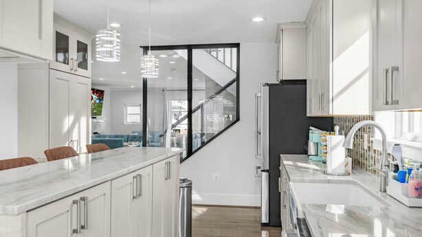 A modern kitchen with white cabinets, a marble countertop, and stainless steel appliances. - Spacious 5-bedroom house in lovely Arlington with AC, WiFi (Arlington)
