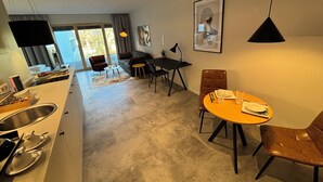 Una cocina moderna con comedor, sofá y televisor.