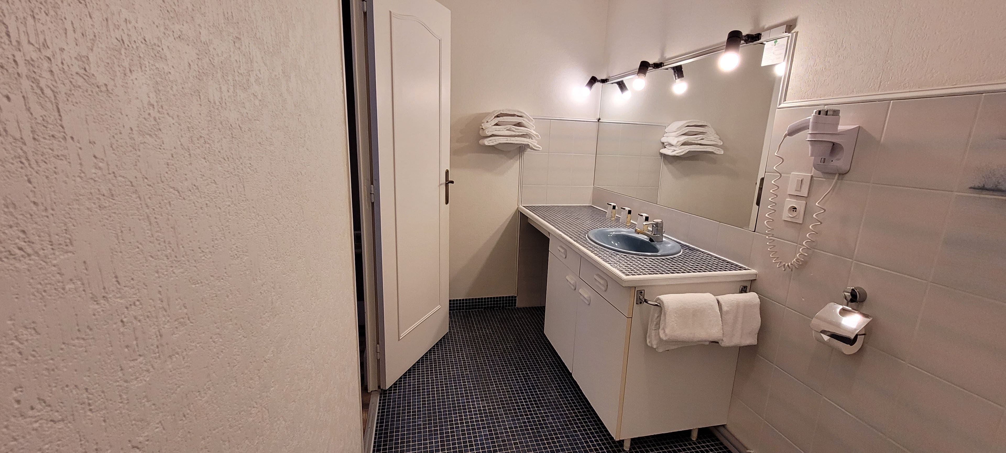 A bathroom with a sink, towel rack, and a mirror.