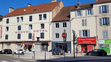 A hotel named 'Nouveau Hotel' with a sign indicating it offers a bakery and patisserie.