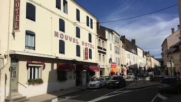 Et hotel kaldet "Nouveau Hotel" med en klassisk facade, mange vinduer og en tydelig indgang.